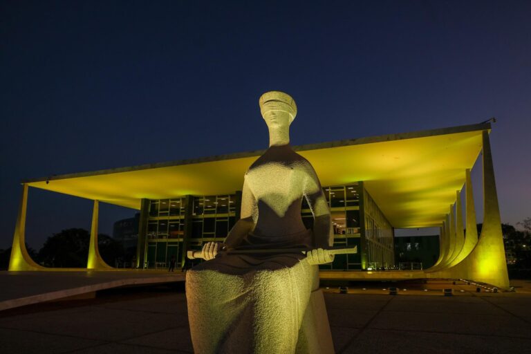 Estátua da Justiça em frente ao prédio do Supremo Tribunal Federal à noite