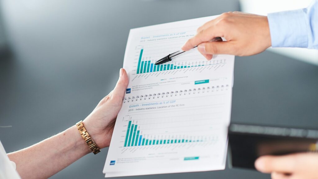 Duas pessoas analisando relatório com gráfico de barras, representando a projeção de caixa da empresa