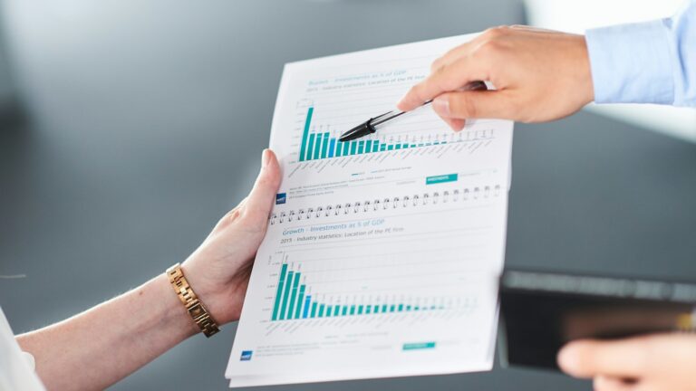 Duas pessoas analisando relatório com gráfico de barras, representando a projeção de caixa da empresa
