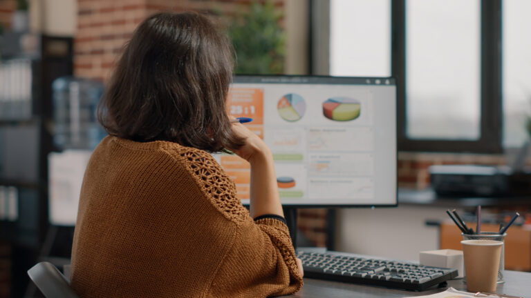 Profissional analisando gráficos no computador para comparar Lucro Real e Lucro Presumido