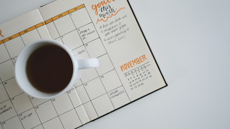 Agenda aberta e xícara de café sobre a mesa, representando o calendário da nova jornada e da Reforma Tributária em 2026 e 2027