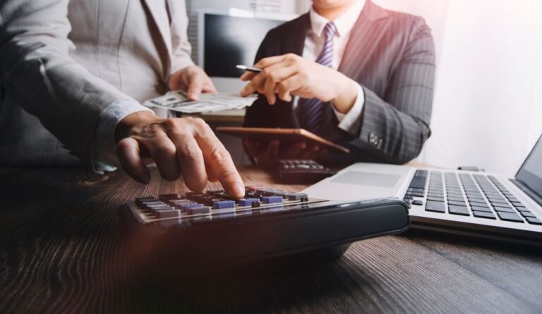 Profissional usando calculadora e laptop para calcular PIS e Cofins, tema do julgamento do STF sobre o ISS na base de cálculo (Tema 118)