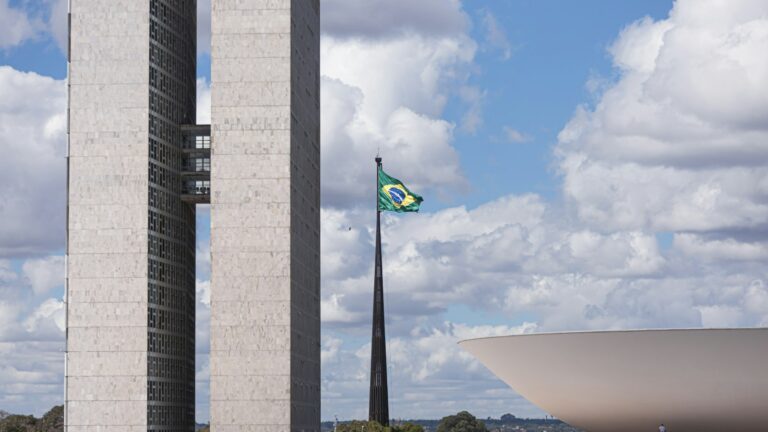 Torres do Congresso Nacional com a bandeira do Brasil, onde uma PEC para adiar a Reforma Tributária precisaria ser aprovada